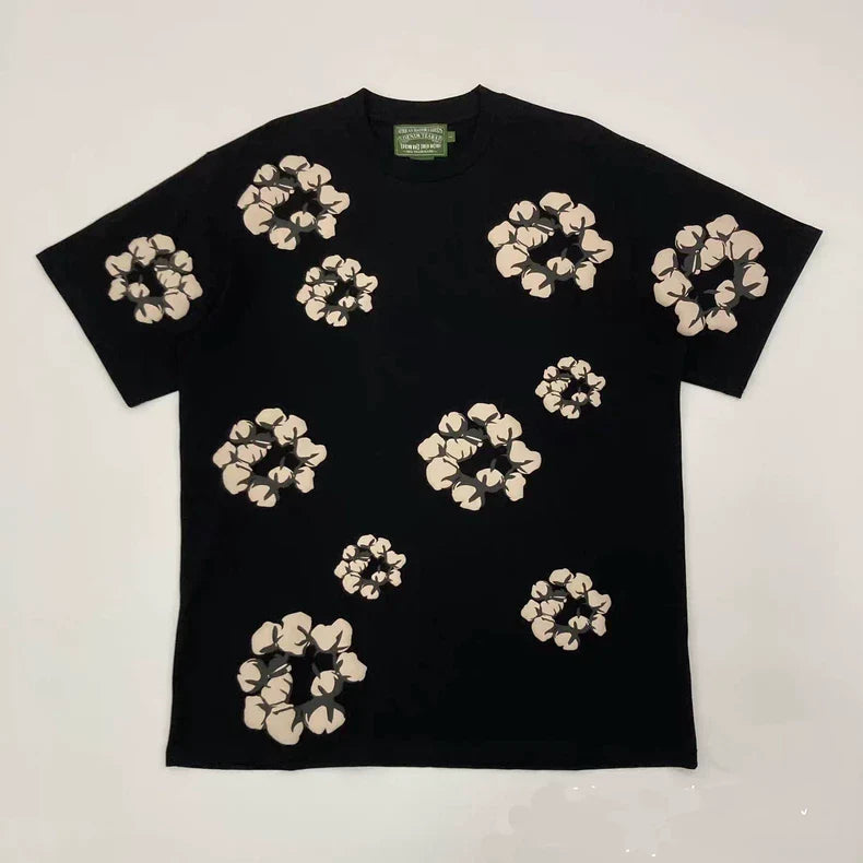 The Denim Tears Black Cotton Wreath Allover Print T-Shirt features multiple beige floral patterns of varying sizes scattered across the front.