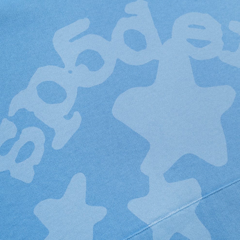 Close-up of baby blue 440GSM heavyweight cotton fleece fabric with star and bubble-like patterns, inspired by Y2K streetwear—like the Sp5der Star Hoodie – Baby Blue Oversized Pullover.