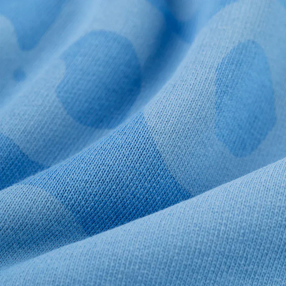 Close-up of baby blue textured fabric with large, darker blue polka dots, similar to the heavyweight cotton fleece of the Sp5der Star Hoodie – Baby Blue 440GSM Oversized Streetwear Pullover.