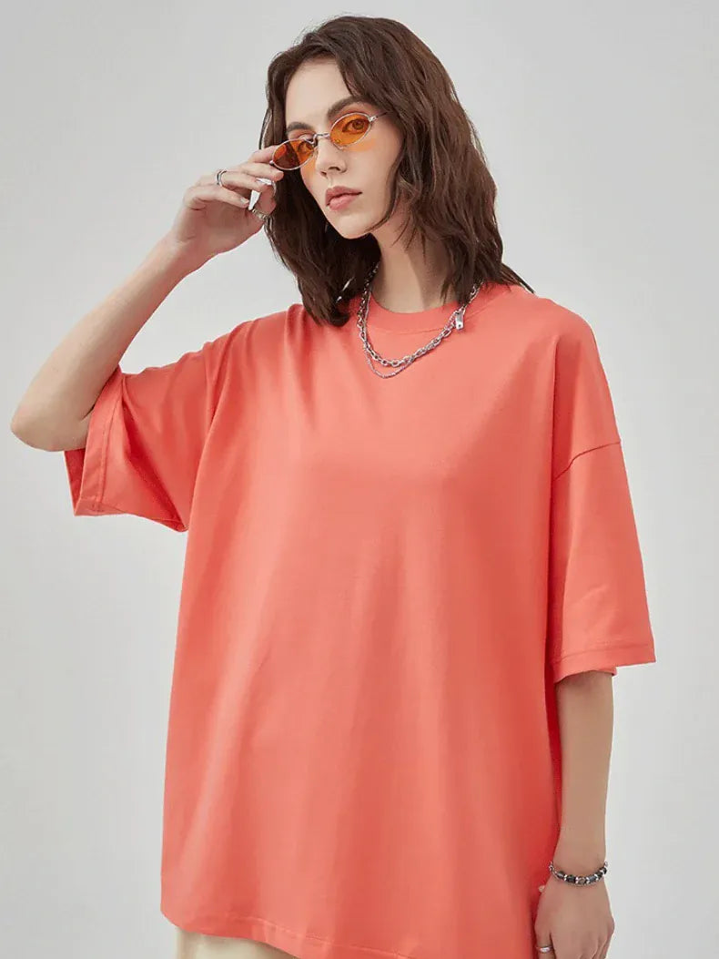 Someone wearing the Custom Anime Character Coral T-Shirt—Personalized 230GSM 100% Cotton Tee—in an oversized fit, styled with orange-tinted sunglasses and a chain necklace, stands in front of a plain light background.