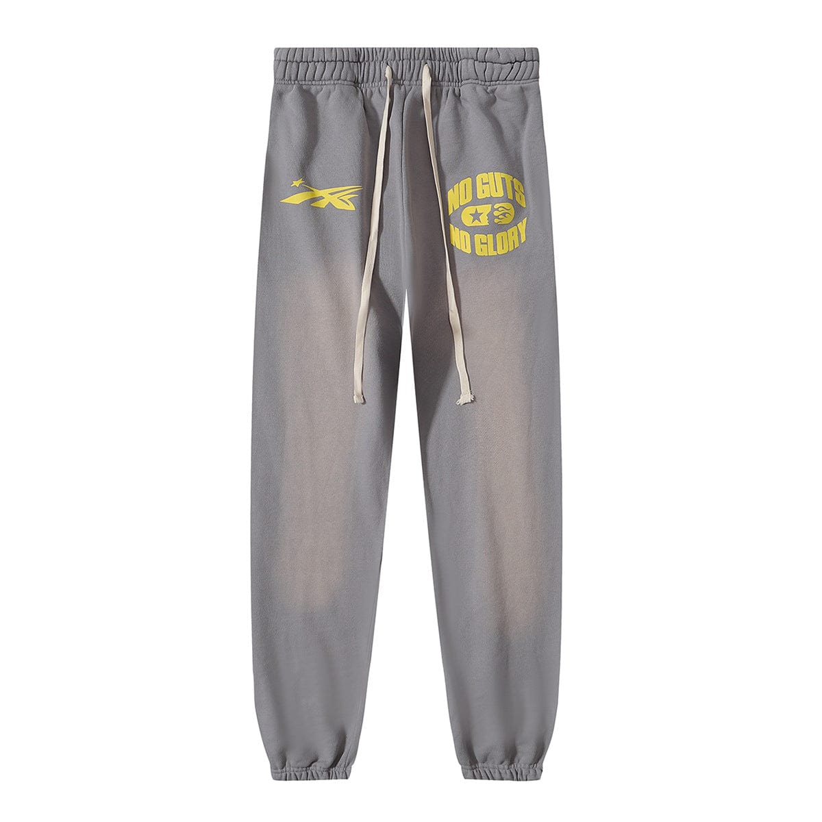 The Hellstar 'No Guts No Glory' Washed Black Yellow Star Sweatpants feature a grey sun-bleached wash, elastic waist, beige drawstrings, and yellow "NO GUTS NO GLORY" graphics on the left thigh.