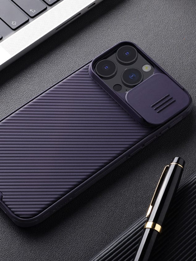 An iPhone 16 Pro Max equipped with a Camera Slider Case, offering anti-scratch, shockproof, and slim fit protection, lies next to a black pen and a laptop on a dark surface.