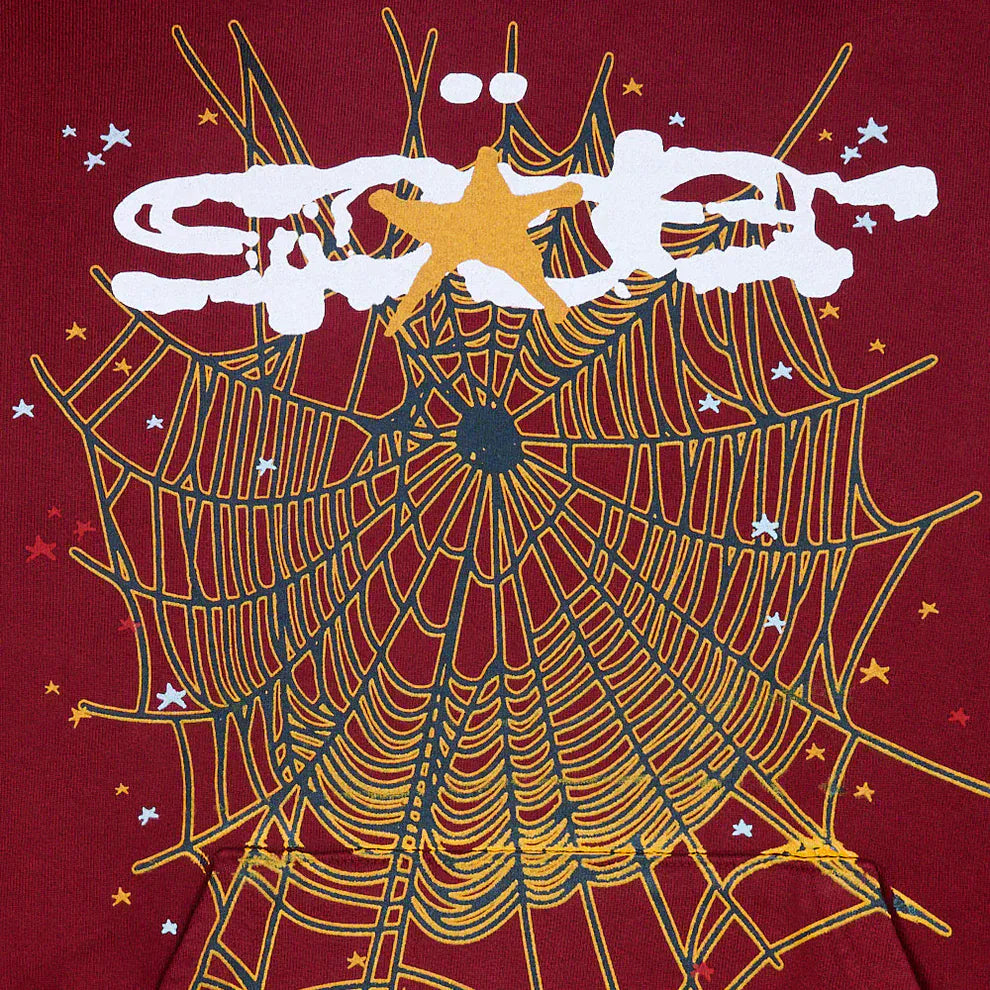 A bold white graffiti-style design featuring a yellow and black spider web with stars pops on a red background—perfect for the Burgundy Graphic Hoodie with Spider Web Print, a 440GSM heavyweight comfort fit pullover hoodie.