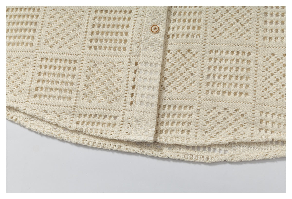 Close-up of the ivory garment's open-knit pattern, button placket, and layered hem.