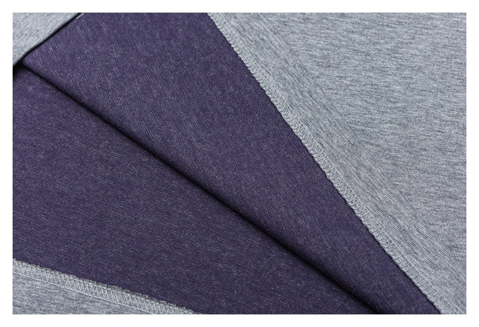 Close-up of dark purple and heather gray fabric panels with an overlocked seam.