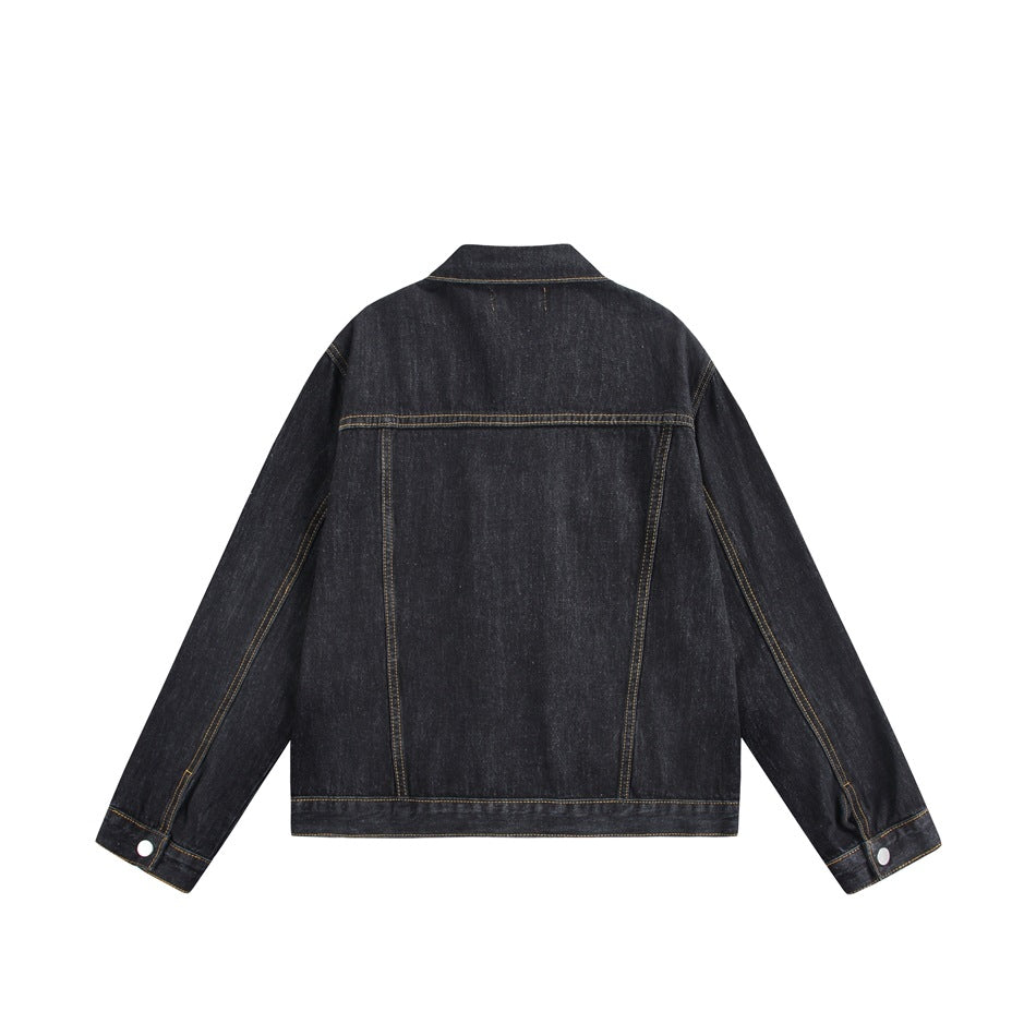 Back view of black washed denim jacket showing yoke seam, vertical panel seams and button cuffs