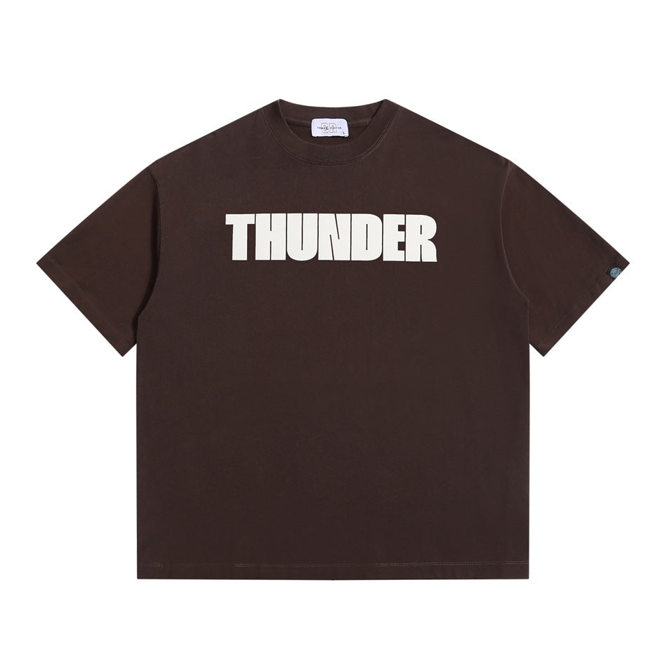 Dark brown short-sleeve crew-neck T-shirt with large white THUNDER block-letter print on chest, flat lay