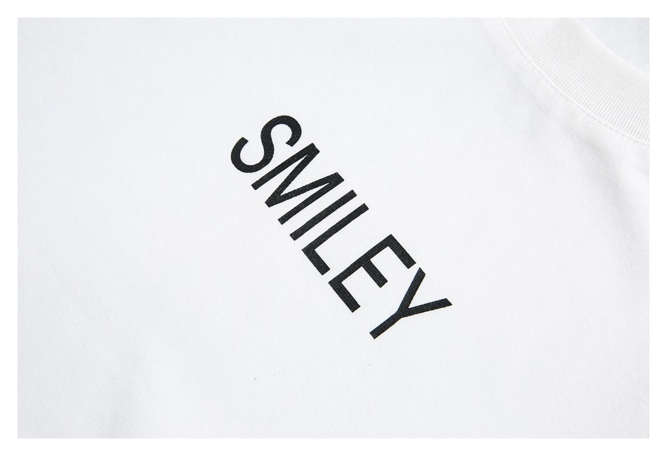 Close-up of black “SMILEY” lettering printed on white T-shirt fabric.