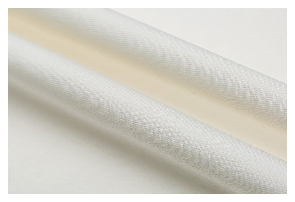 Macro view of the off-white T-shirt fabric, showing its knit texture and folds.