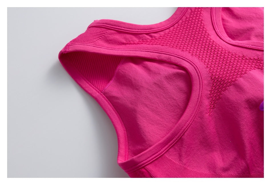 Close-up of a pink athletic top's armhole, shoulder strap, and mesh back panel.