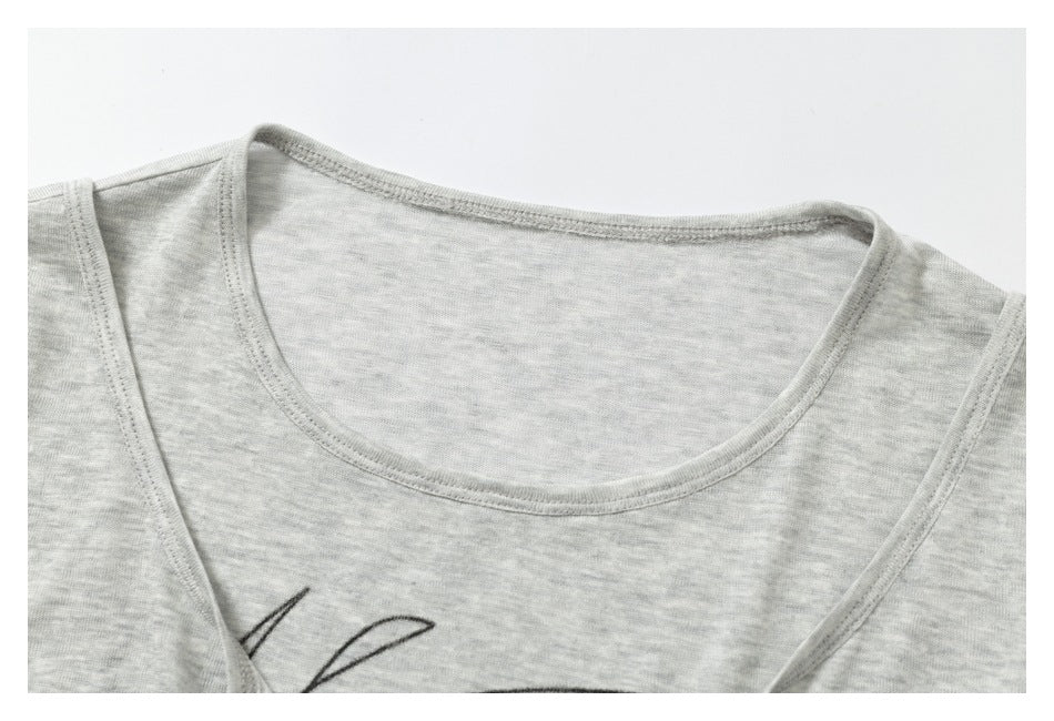 Close-up of a light gray heather shirt's rounded neckline, shoulder seams, and part of its black line graphic.