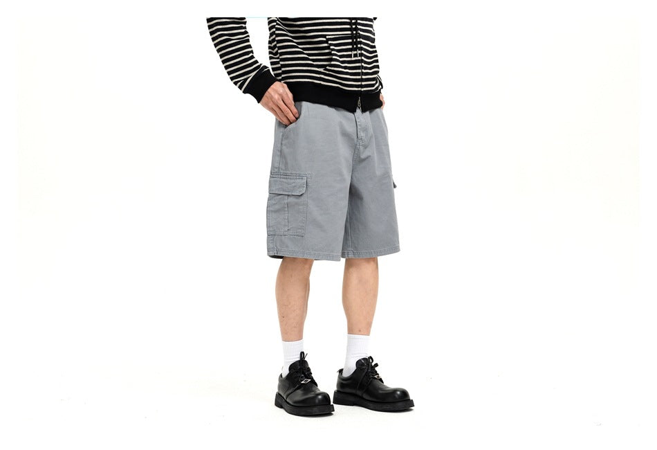 Angled front view of a model wearing light gray cargo shorts with a flap side pocket.