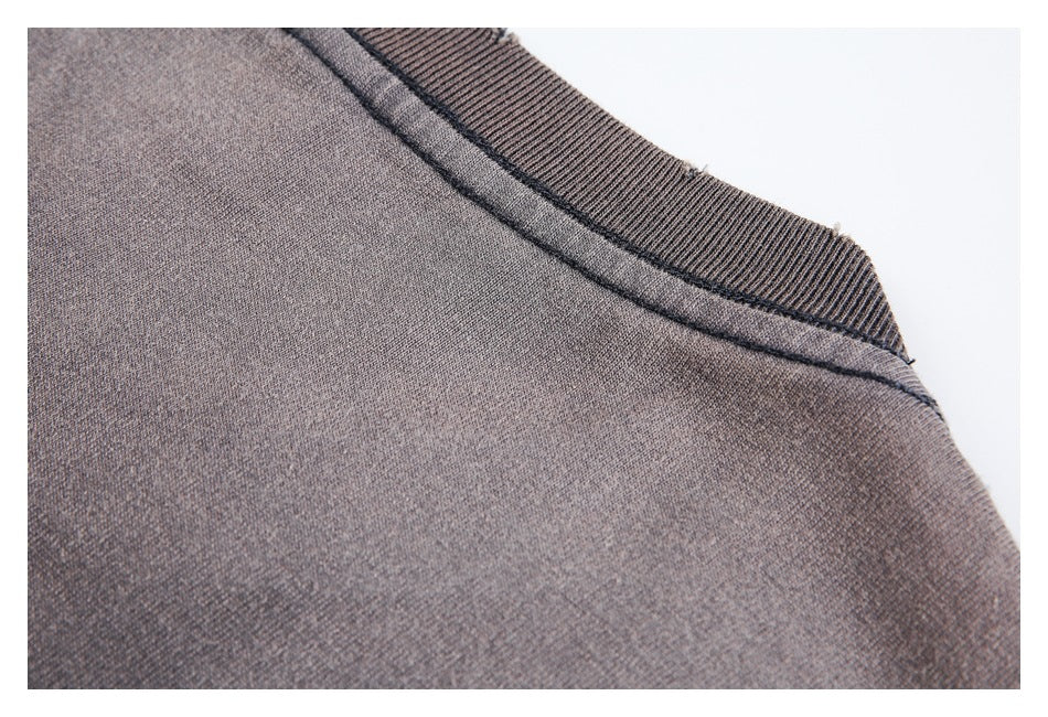 Close-up of the charcoal-brown neckline and shoulder seam with ribbed trim.