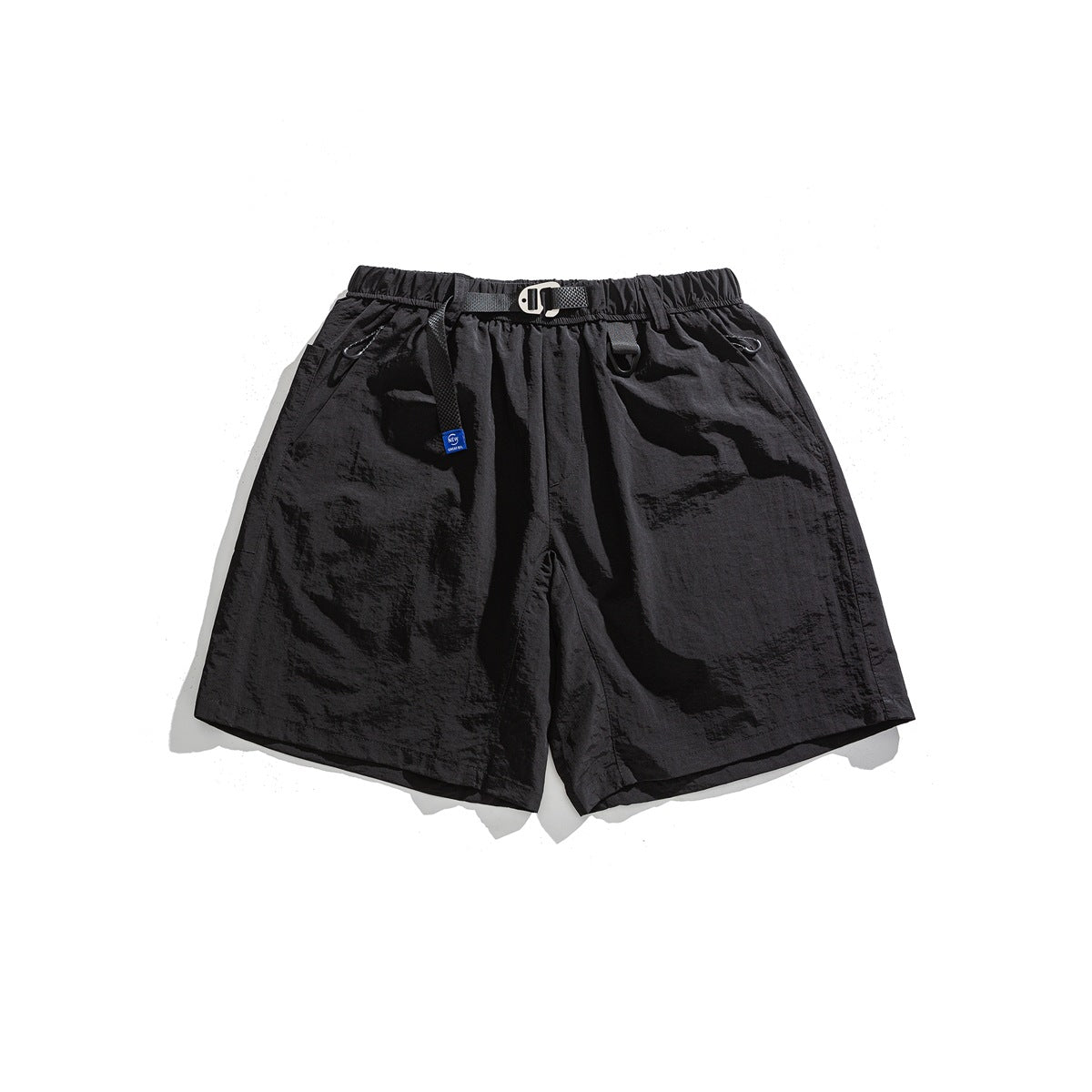 Black crinkled shorts with elastic waist, webbing belt with metal buckle and blue label, flat lay front view
