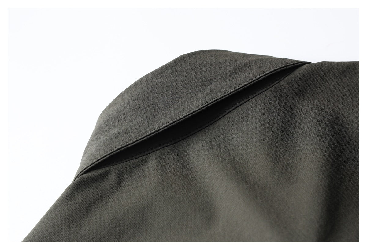Close-up of a pointed collar on a dark olive garment.
