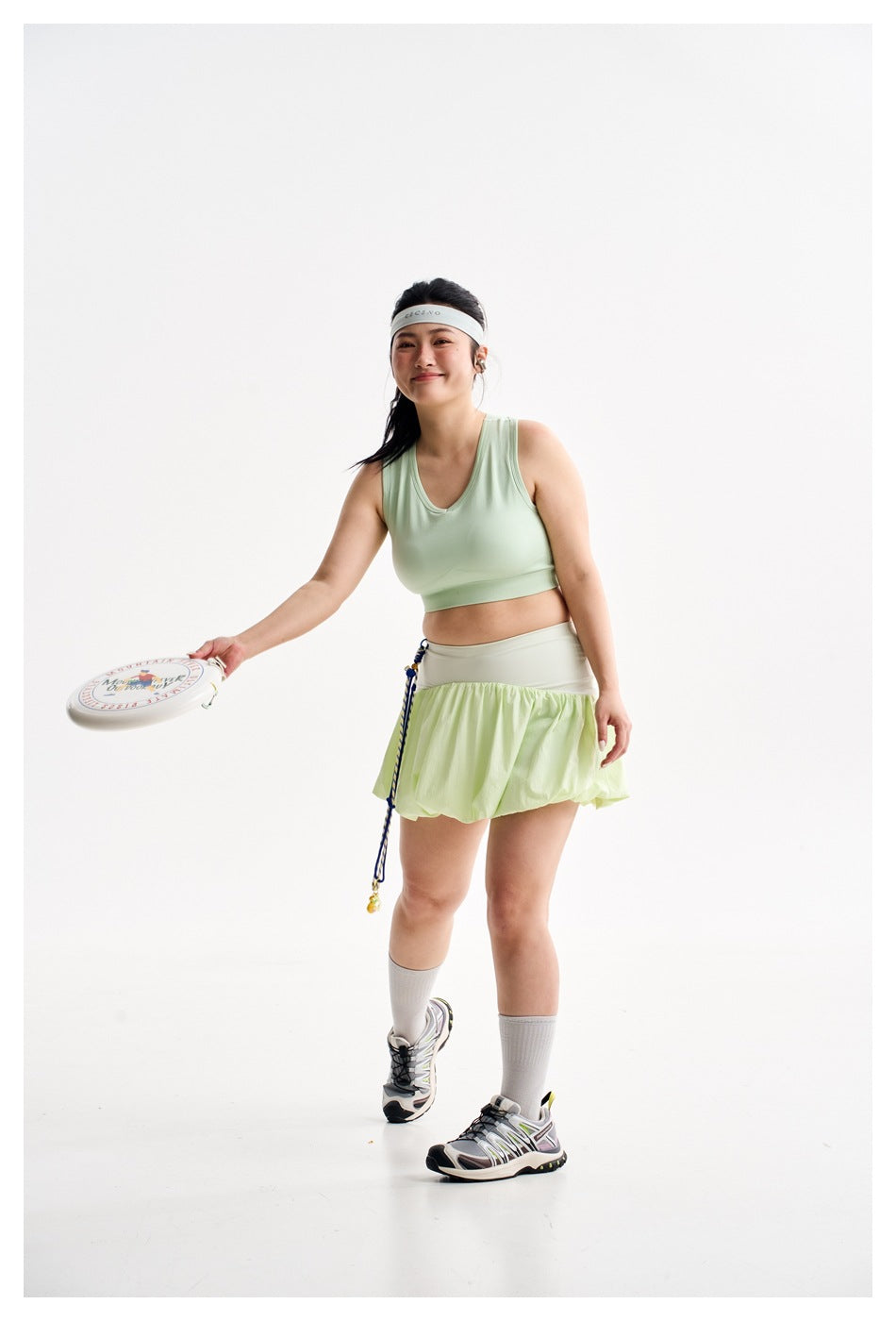 Front view of a model wearing a pale mint sleeveless crop top and light green bubble-hem skirt.