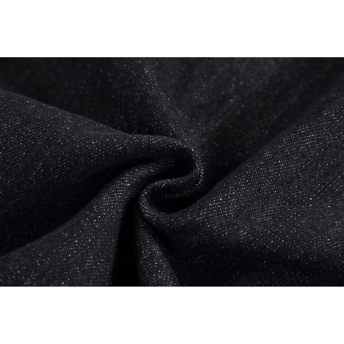 Macro view of dark denim fabric gathered to show its woven texture.