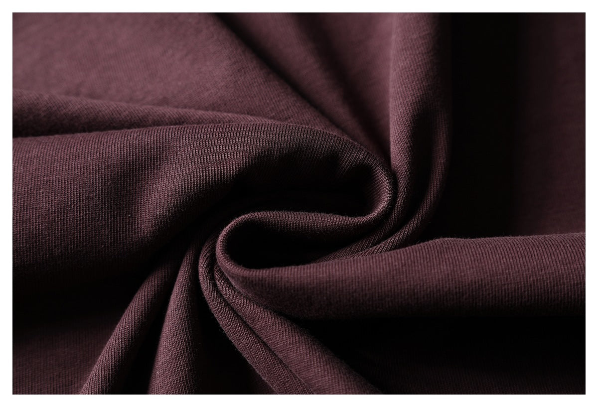 Close-up of dark burgundy fabric gathered into soft folds, showing its fine knit texture.