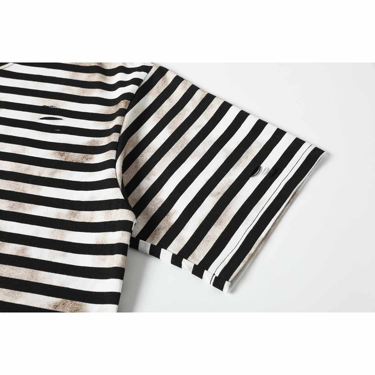 Close-up of a short sleeve on a black-and-cream striped T-shirt, with faded marks and a small distressed slit.