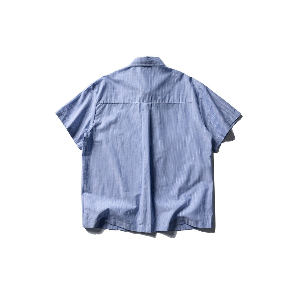 Back view of a light blue, fine white-striped short-sleeve collared shirt laid flat.