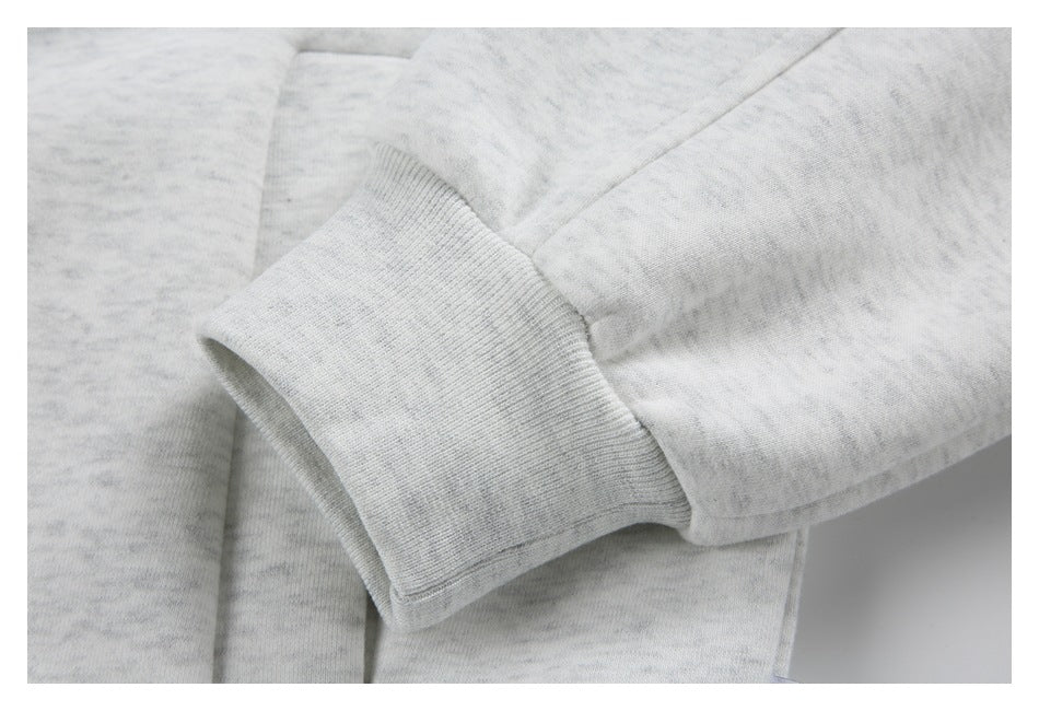 Close-up of a light gray heather sweatshirt sleeve and wide ribbed cuff.