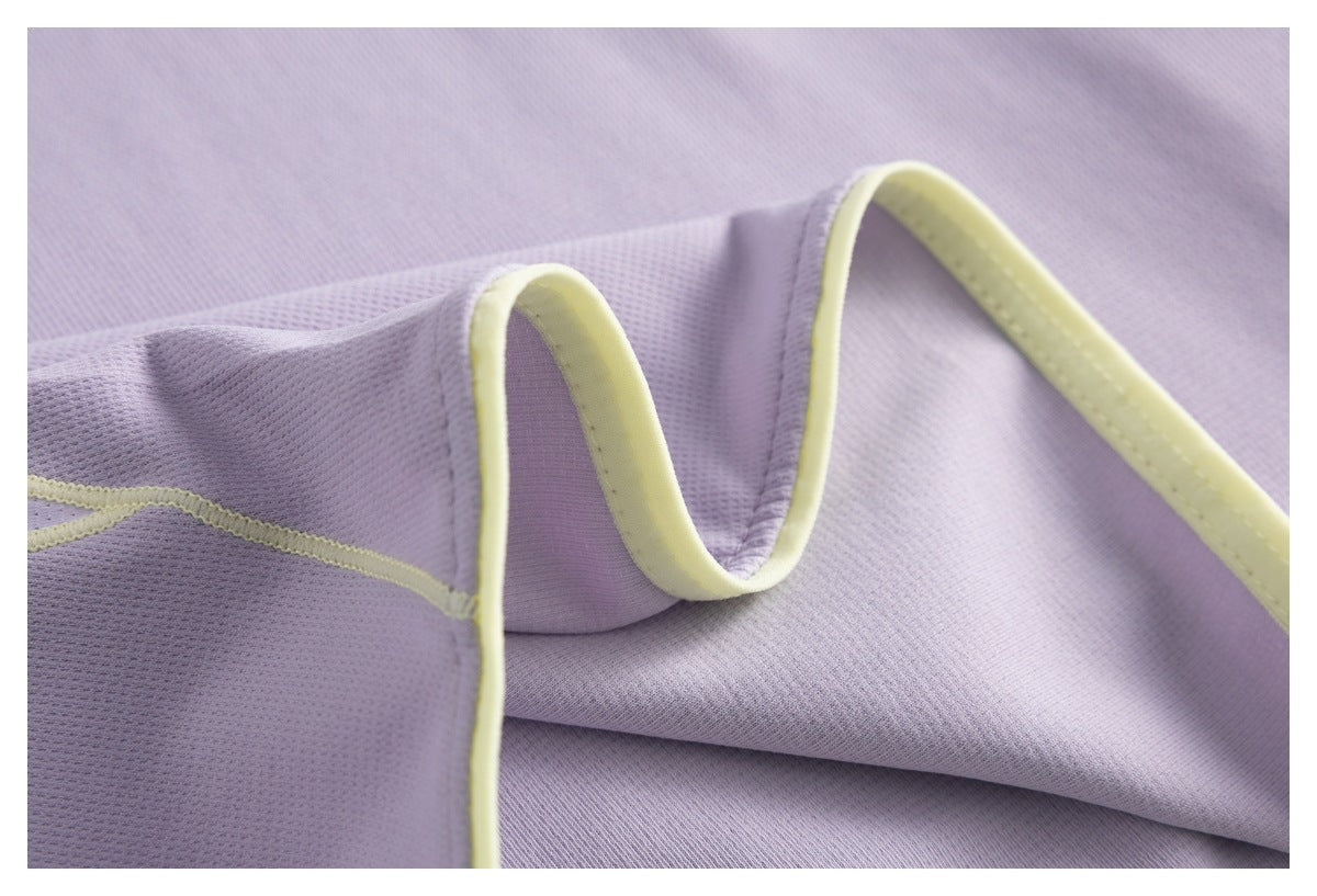 Close-up of lavender fabric folds and a curved seam finished with pale yellow binding.