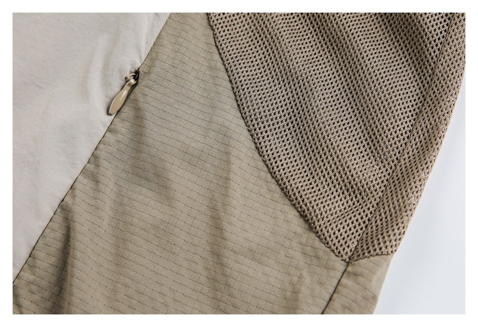 Close-up of a beige jacket panel with a mesh section and zipper pocket.