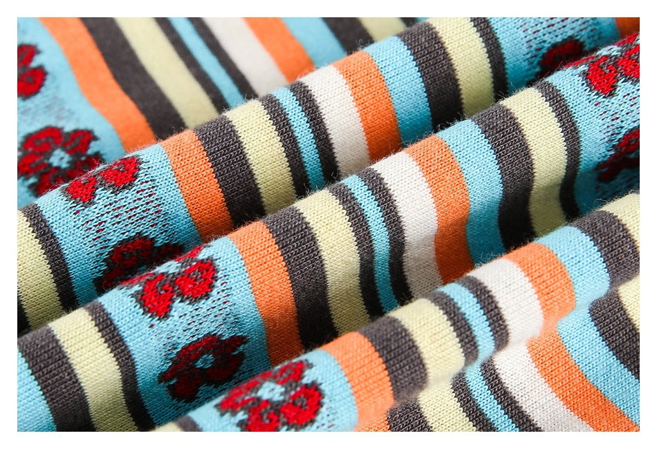 Close-up of folded striped knit fabric with red flower motifs, showing its textured surface.