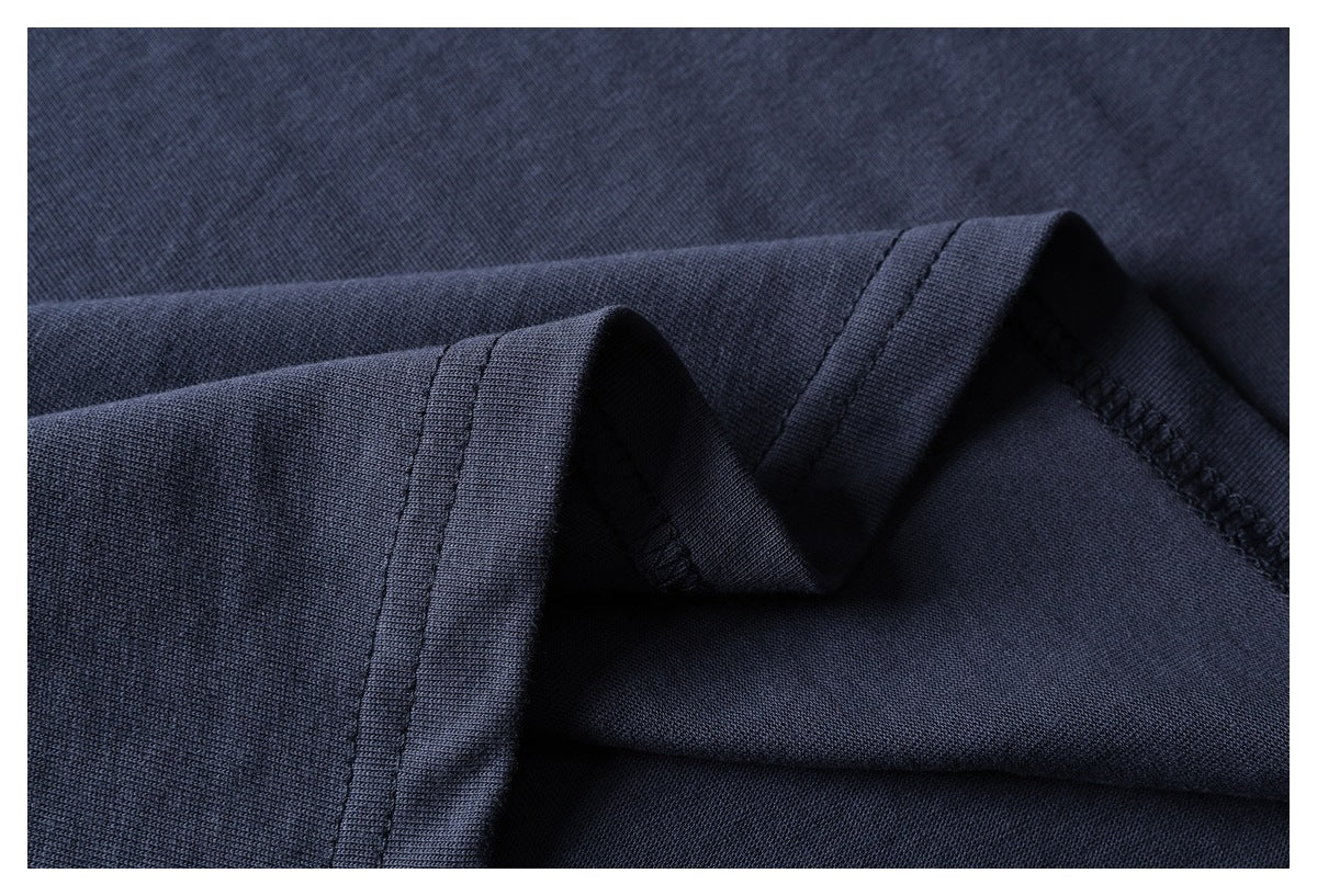 Close-up of dark navy garment fabric folded to show a stitched edge and seam.