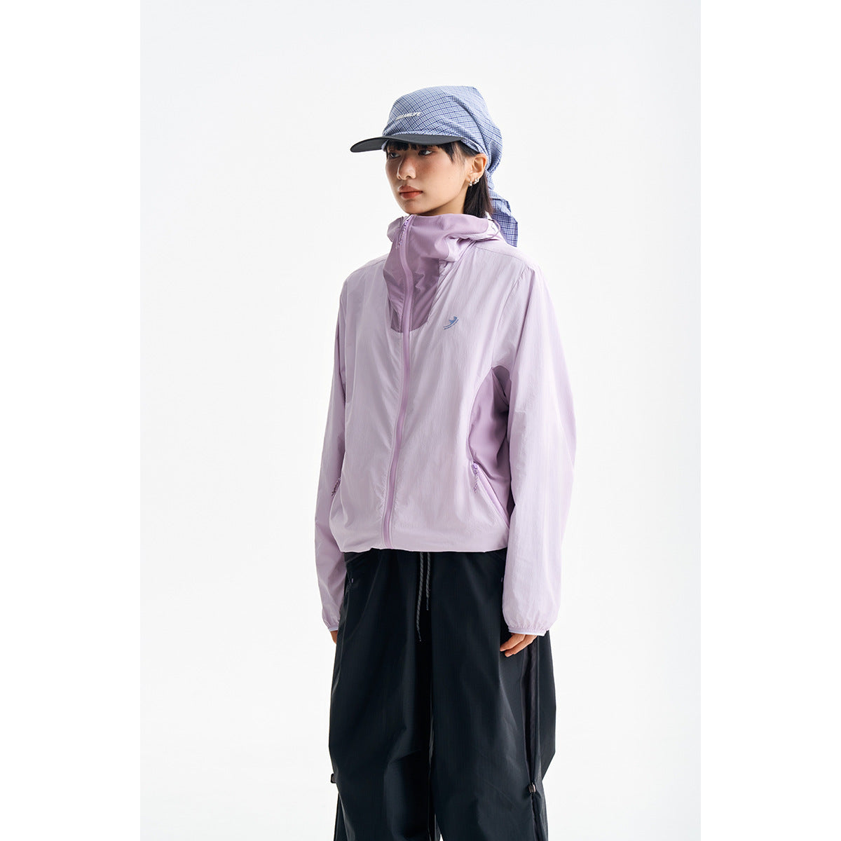Model wearing a light lavender hooded zip jacket with black trousers against a white background.