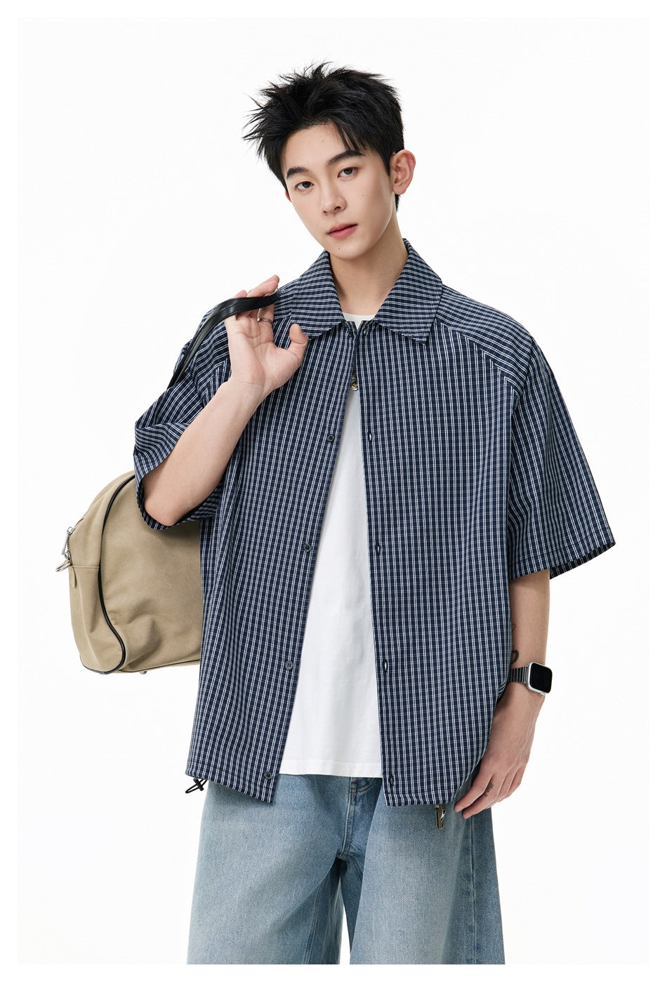 Model wearing a navy-and-white checked short-sleeve button-up shirt over a white T-shirt.