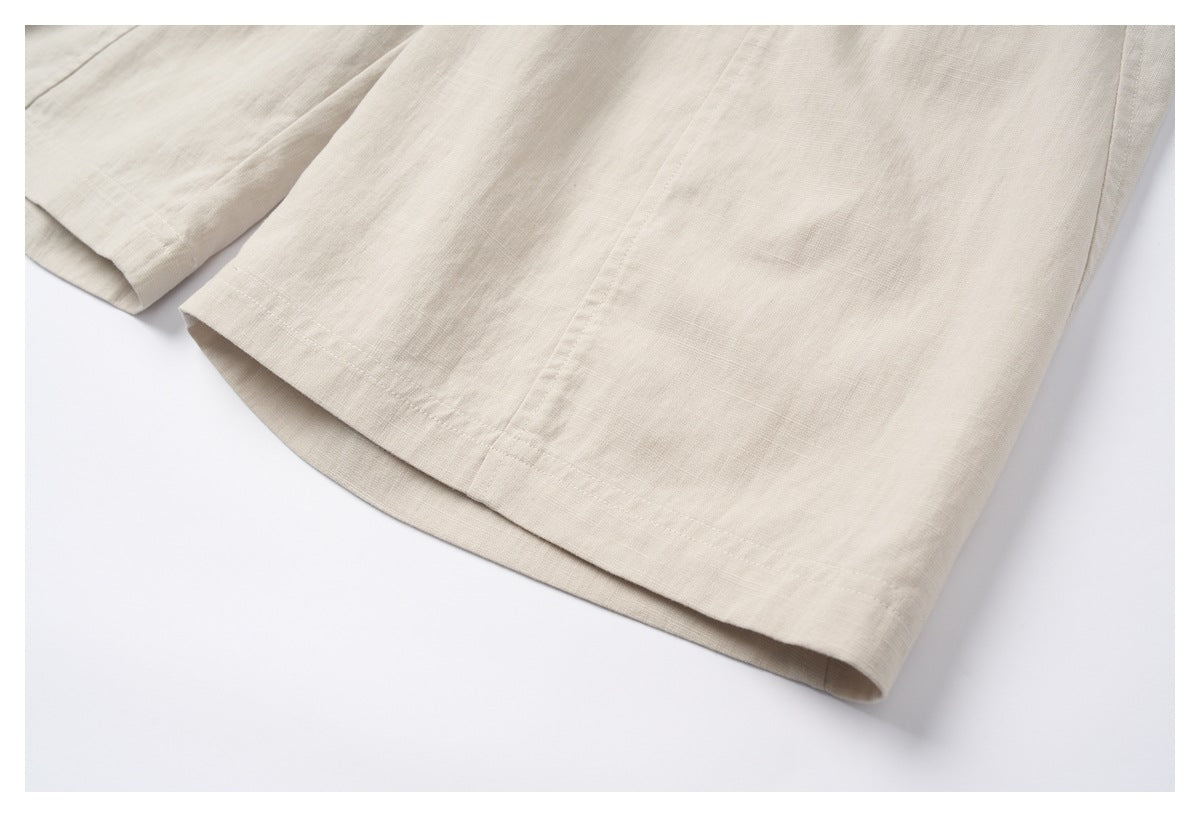 Close-up of a cream garment's hem and vertical seam against a white background.