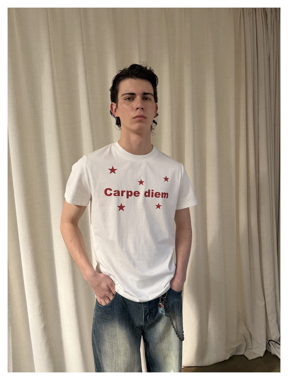 Front view of a model wearing a white T-shirt with red “Carpe diem” text and stars.