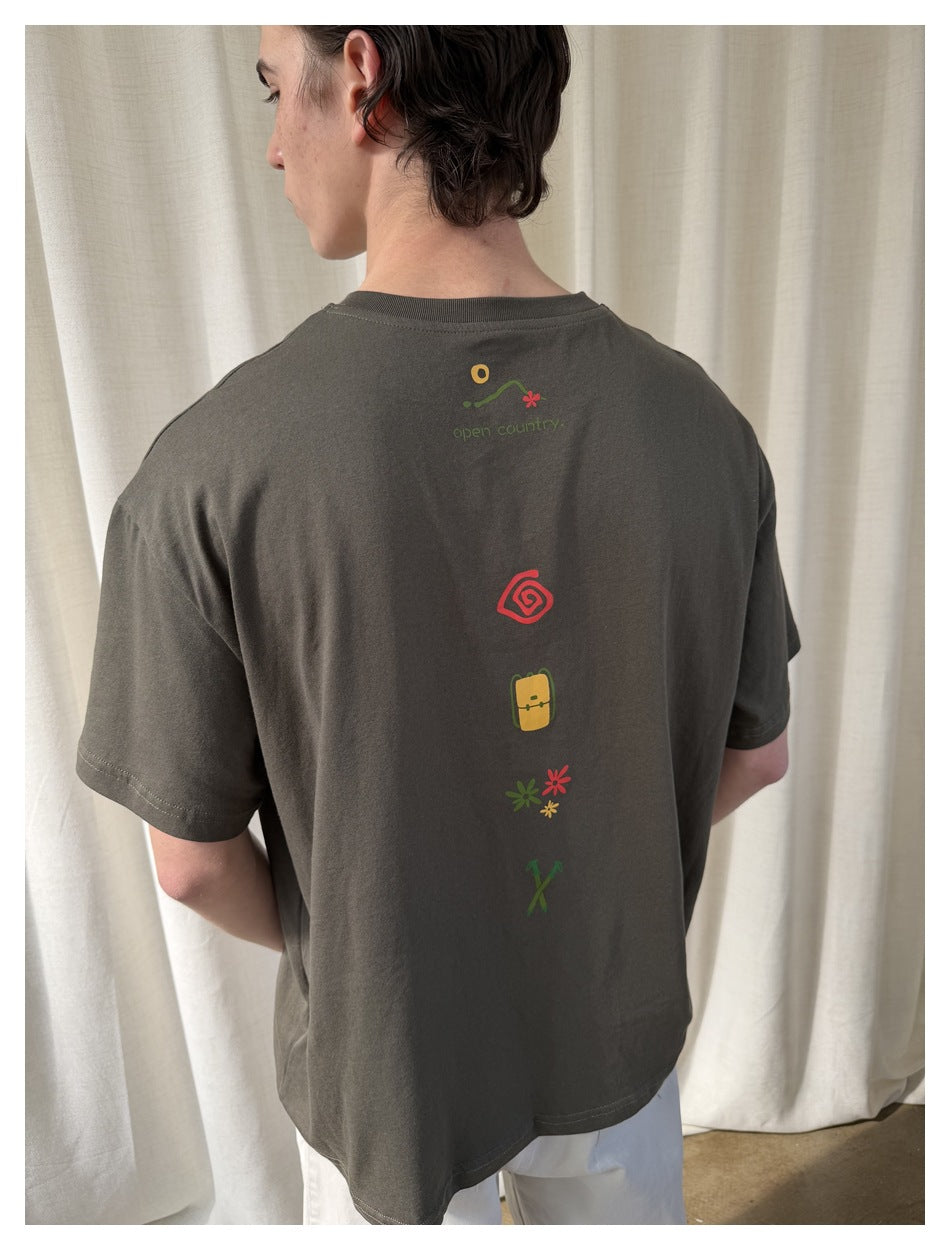 Close-up of the charcoal brown T-shirt's back, showing a vertical row of colorful outdoor-themed graphics.