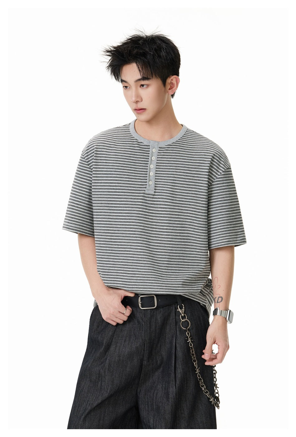 Closer view of a model wearing a gray striped henley with a gray placket and light buttons.