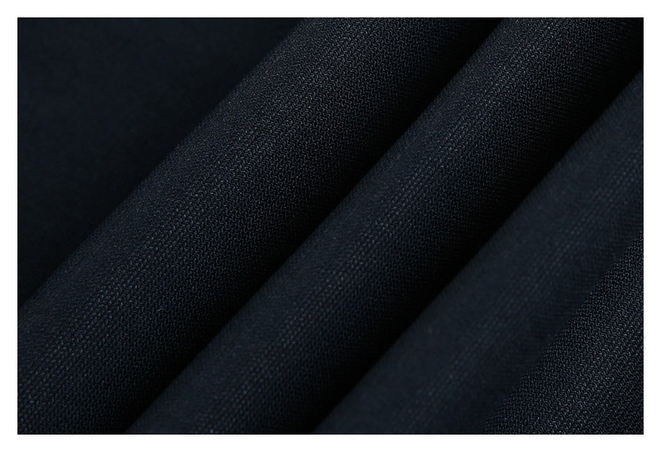 Close-up of the fine woven texture of dark navy fabric arranged in folds.