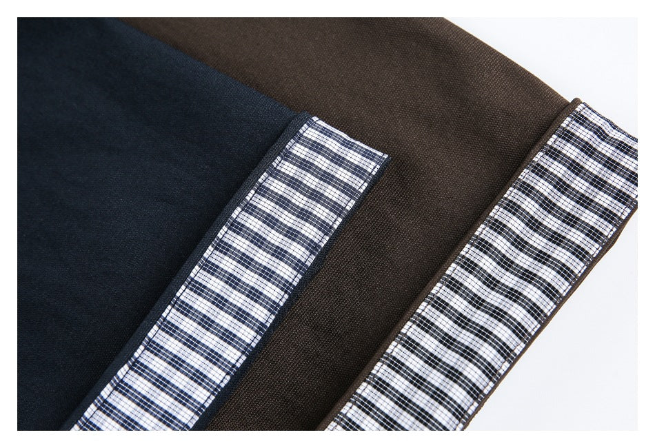 Close-up of navy and brown jacket edges with black-and-white checked trim.