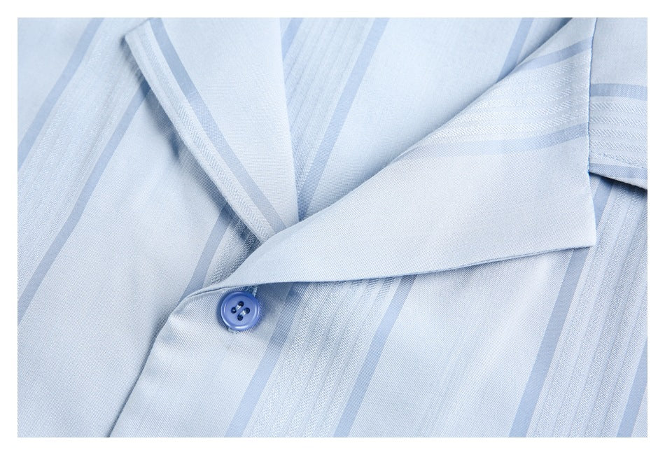 Close-up of the light blue striped shirt collar and a blue button.