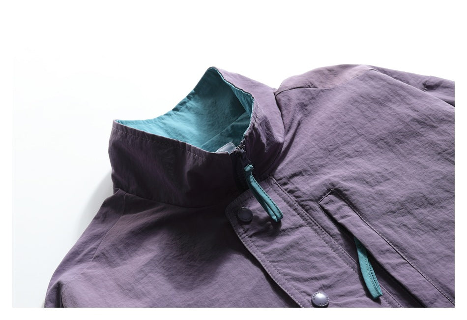 Close-up of the purple jacket's raised collar, turquoise lining, zipper pull, and snap-button placket.