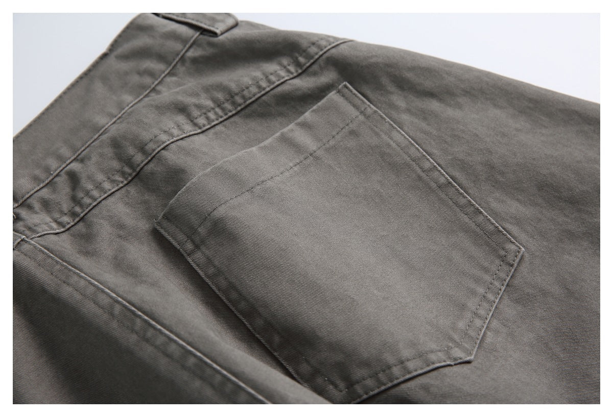 Close-up of charcoal-gray trousers showing a stitched back pocket and waistband.
