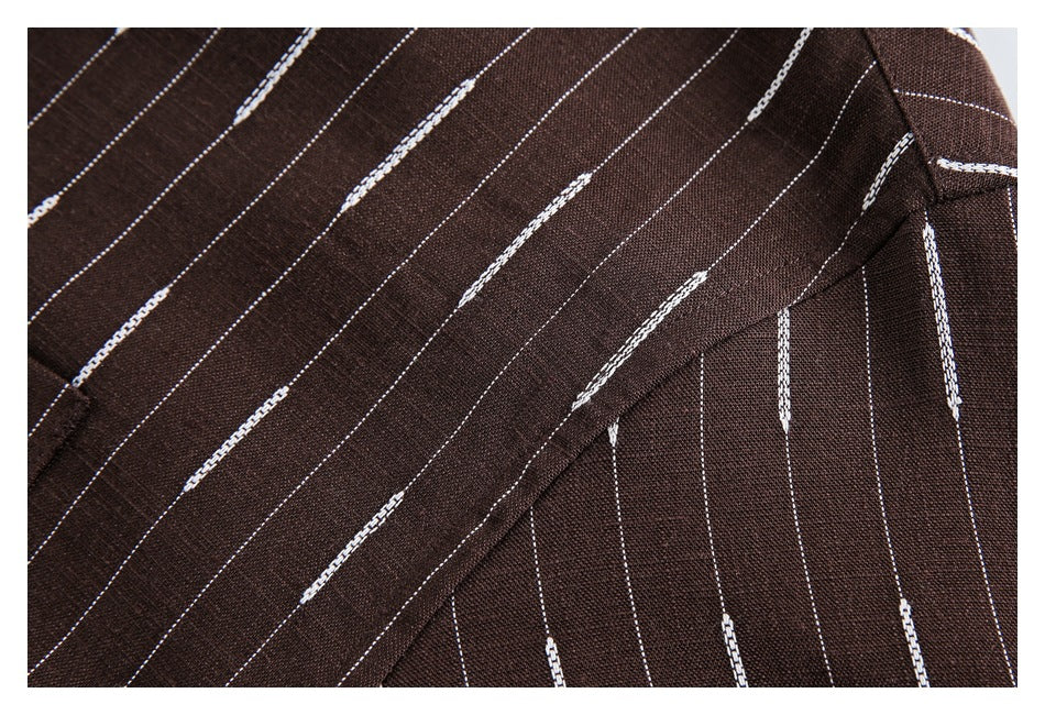 Close-up of dark brown fabric with thin white stripes, showing a folded seam and stitching.