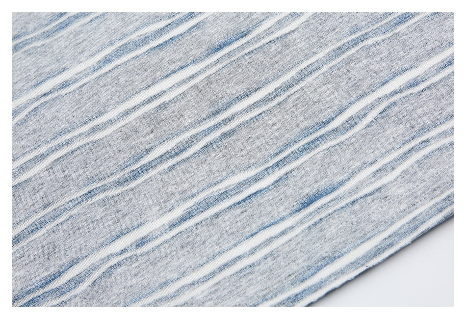 Close-up of gray knit fabric with irregular narrow blue and white stripes.