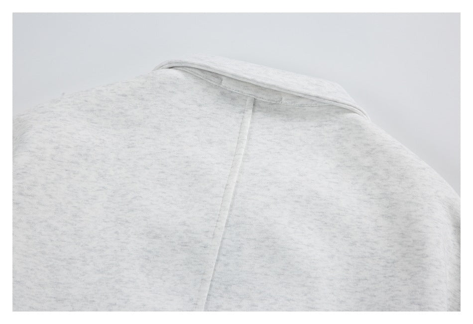 Close-up of the back neckline and center seam of a light gray marled garment.