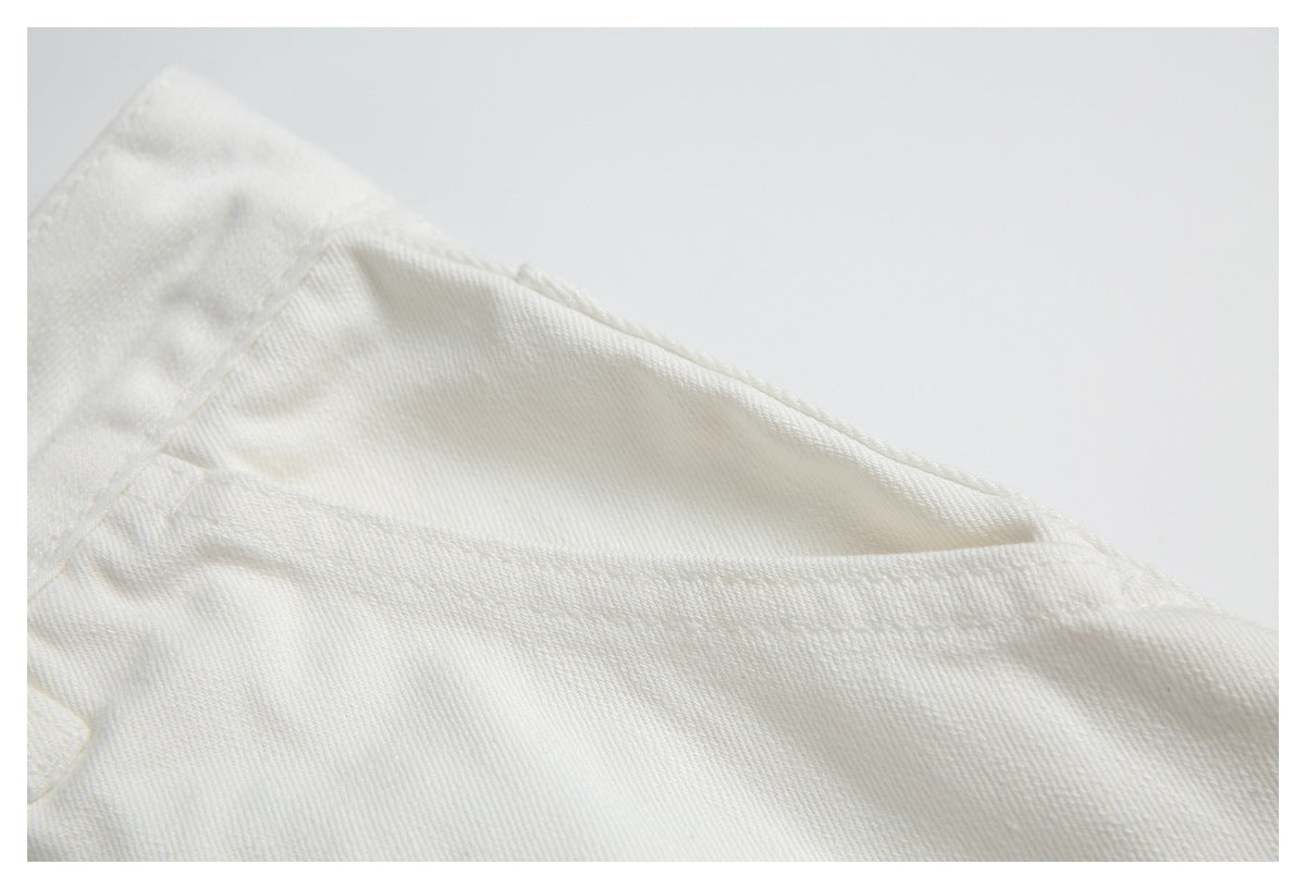Close-up of off-white twill fabric showing a folded seam and fine diagonal weave.