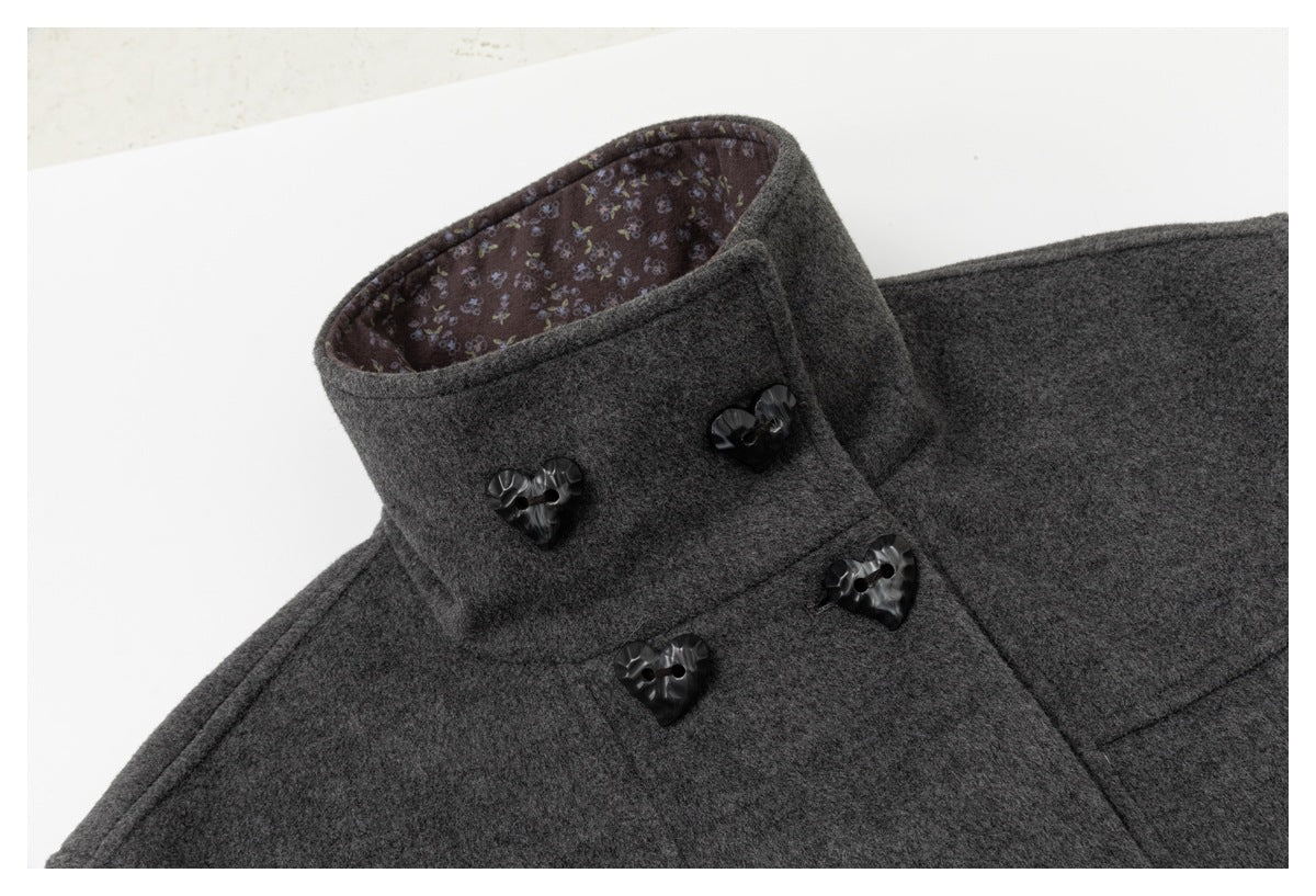 Close-up of the charcoal coat's high collar, floral-patterned lining, and glossy heart-shaped buttons.