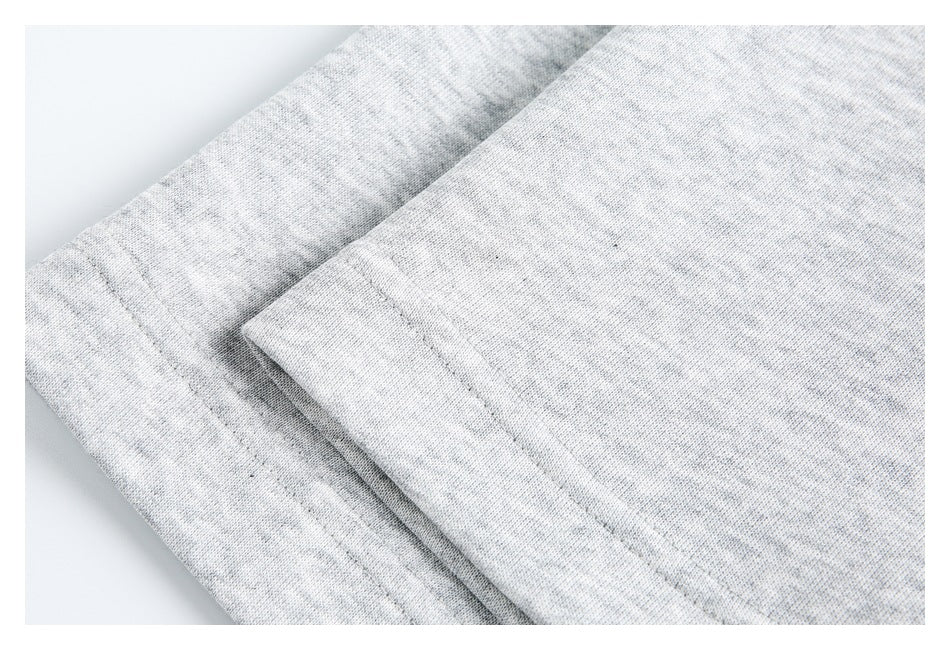Close-up of the light gray shirt's folded edge and parallel stitching.
