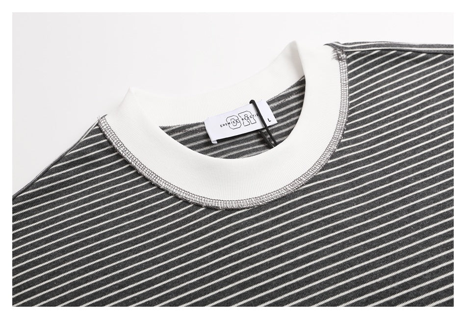 Close-up of a charcoal gray and white striped shirt with a wide white ribbed crew neckline and neck label.