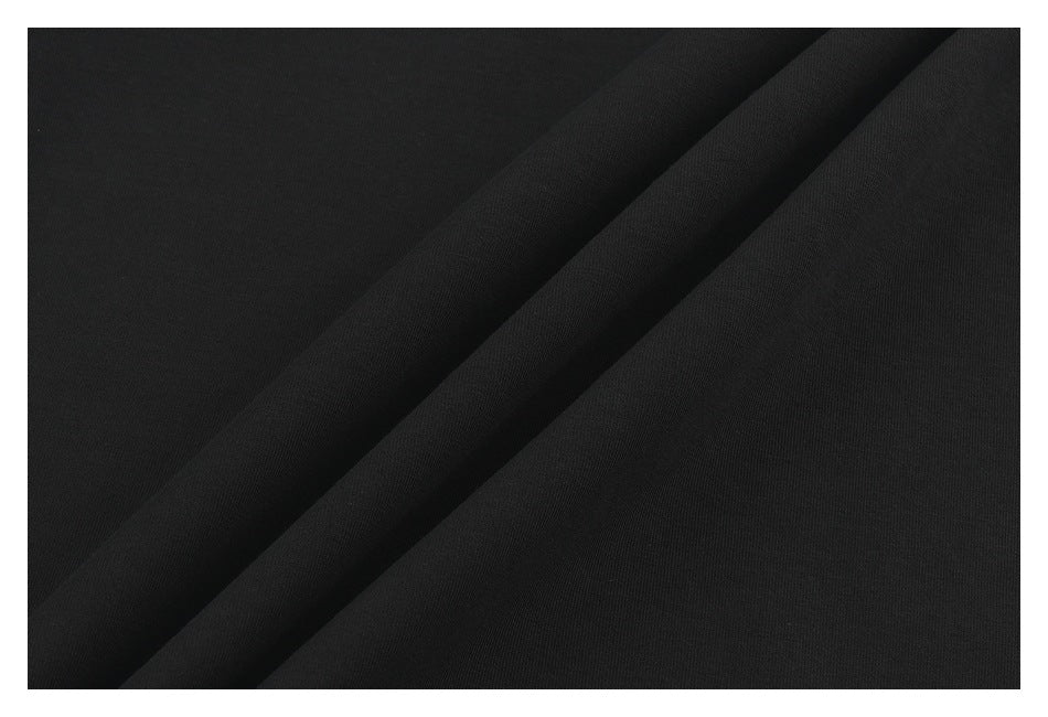Close-up of black fabric arranged in diagonal folds, showing its surface texture.