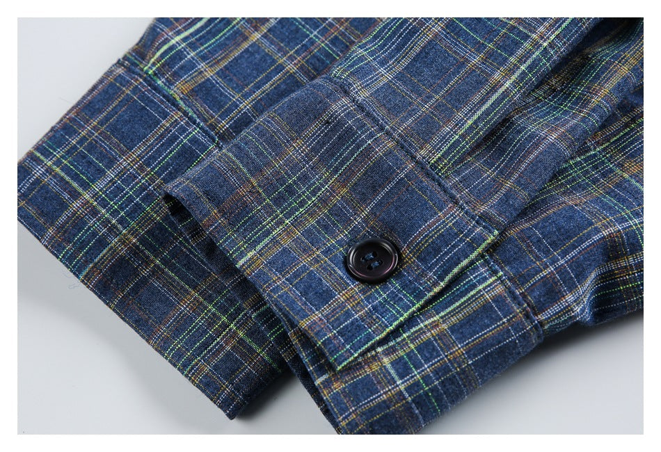 Close-up of a dark button on a dark blue plaid garment, showing the fabric and stitching.