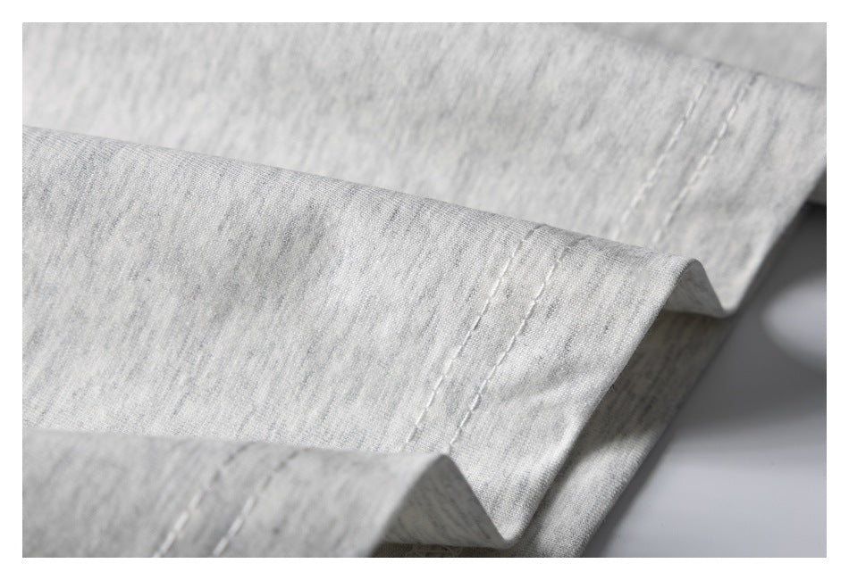 Close-up of the double-stitched hem on light gray marl fabric.